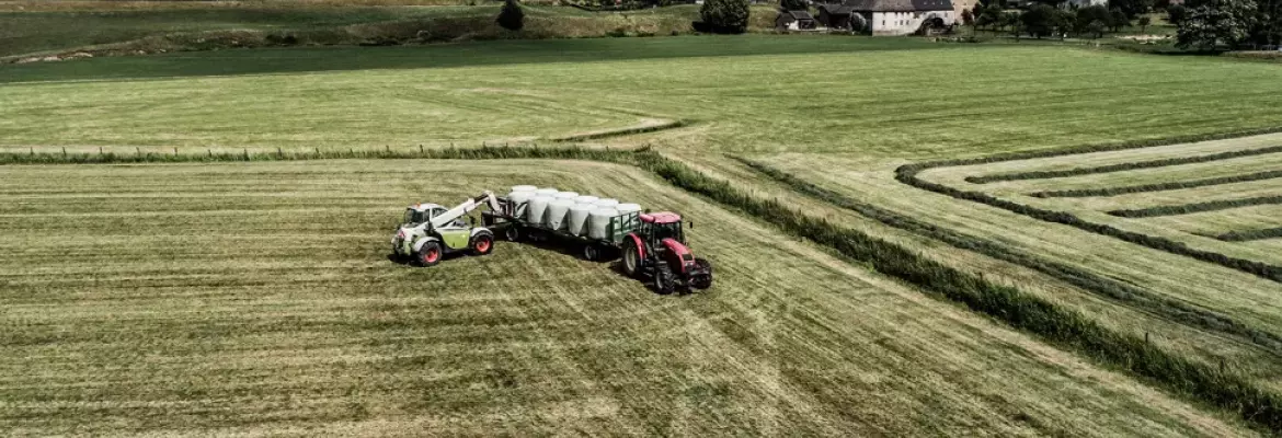 Photo illustrant un tracteur qui stock des balles rondes enrubannées