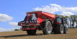 Rozsiewacz nawozów AXENT podczas pracy na polu