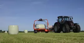 Owijarka okr?g?ych bel RW 1800 w trakcie owijania bel na polu