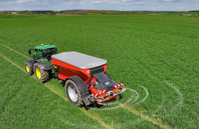 Rozsiewacz nawozów AXENT podczas pracy na polu