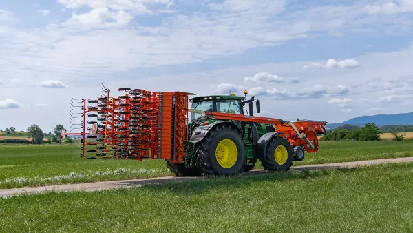 Zestaw wysiewający podczas transportu drogowego, składający się z brony wirnikowej HR 4530 RCS i belki wysiewającej BTFR 4530