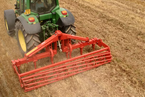 Widok z tyłu na spulchniacz gleby podczepiony do ciągnika