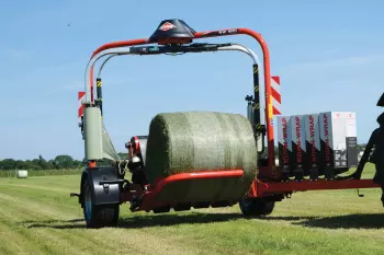 Unikalny system ładowania bel z długim ramieniem ładującym zintegrowanym ze stołem owijającym.