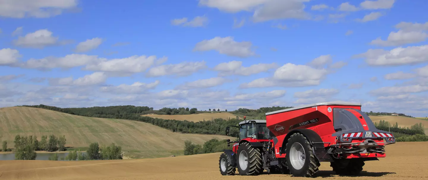 Rozsiewacz nawozów AXENT podczas pracy na polu