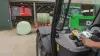 Włączanie stojącego przed oborą modelu owijarki RW 1110 za pomocą pilota zdalnego sterowania. W tle robot podający.